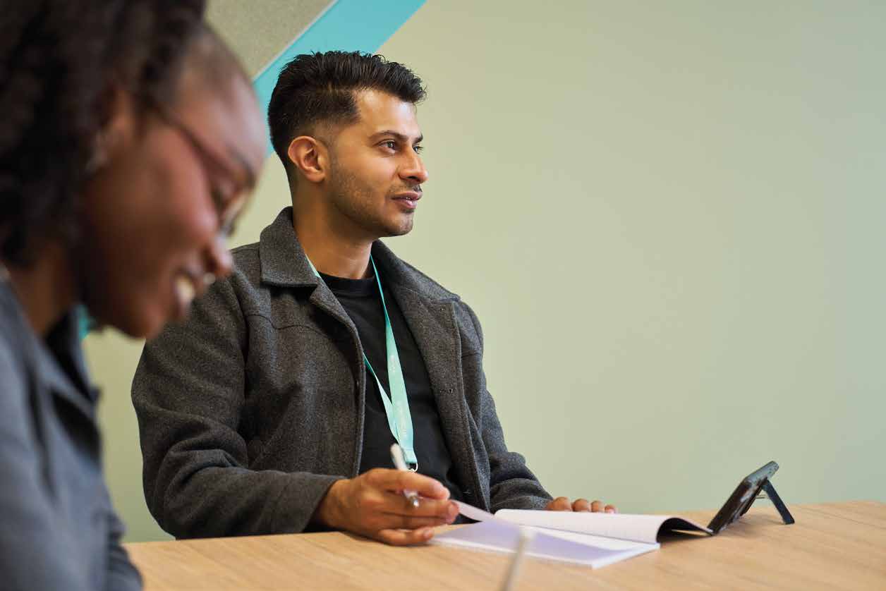 An Arden student talking through ideas at a table