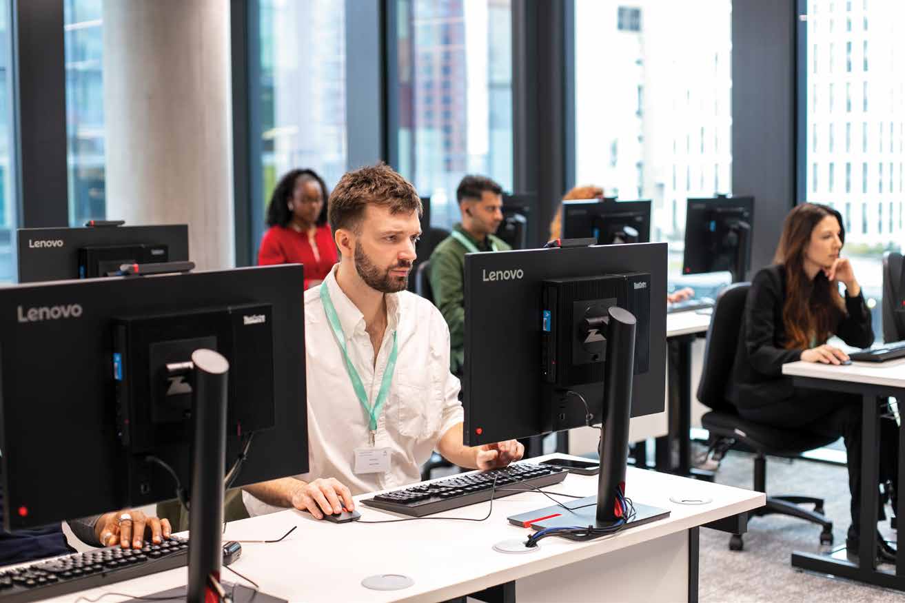 Students working at desktop computers in an Arden computer room
